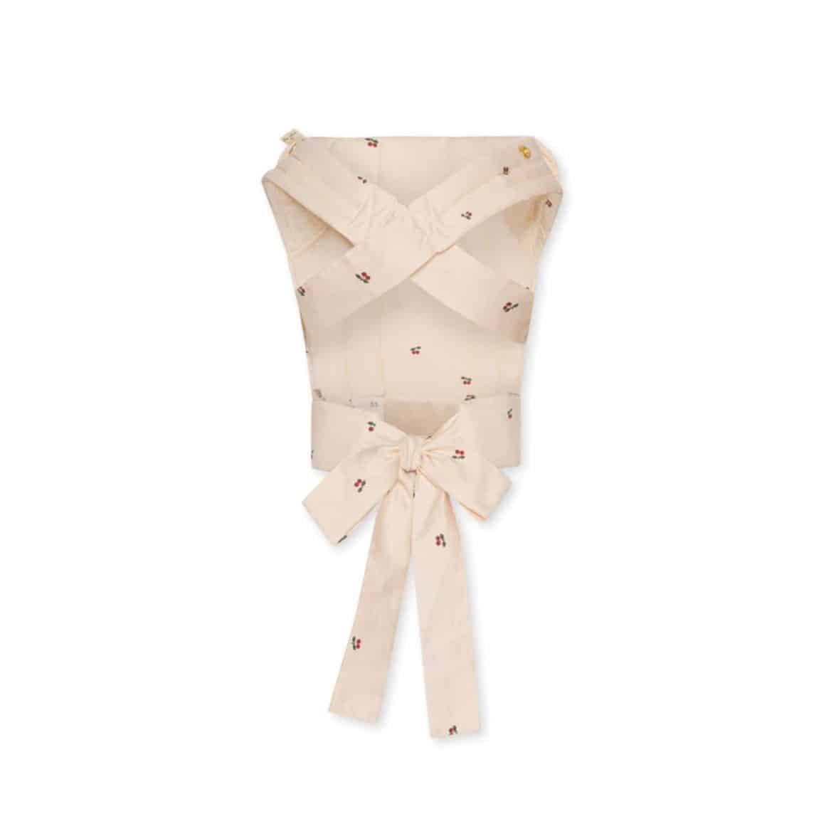 Un porte poupée avec des motifs cerises de la marque konges