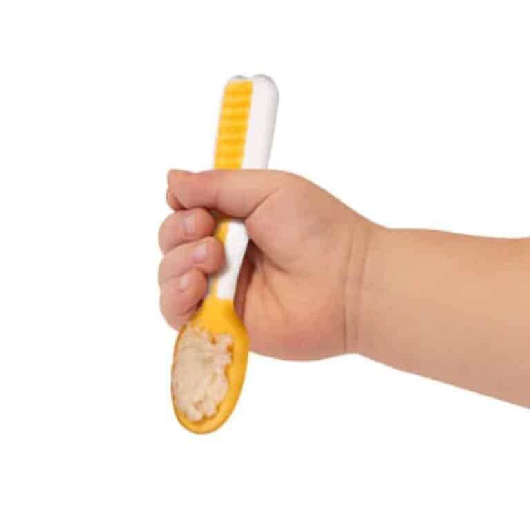 pre cuillere d'apprentissage jaune tenu par main enfant