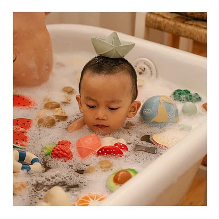 jouet de dentition avec bateau origami menthe sur la tête dans le bain