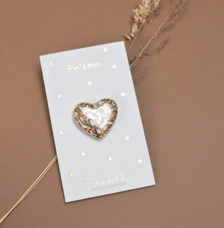 pin's cœur blanc et doré baubels vue de face sur fond coloré