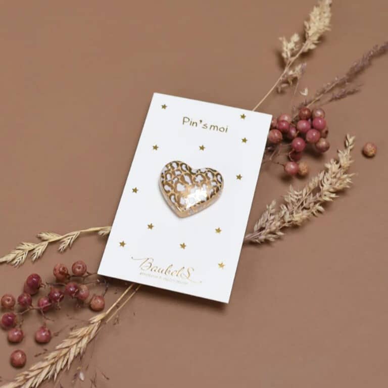 pin's cœur blanc et doré baubels vue de face sur fond coloré