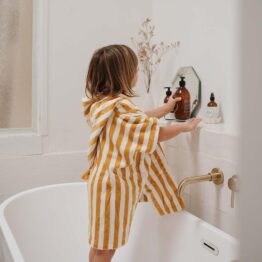 Un poncho de bain en éponge moutarde de la marque rose in april