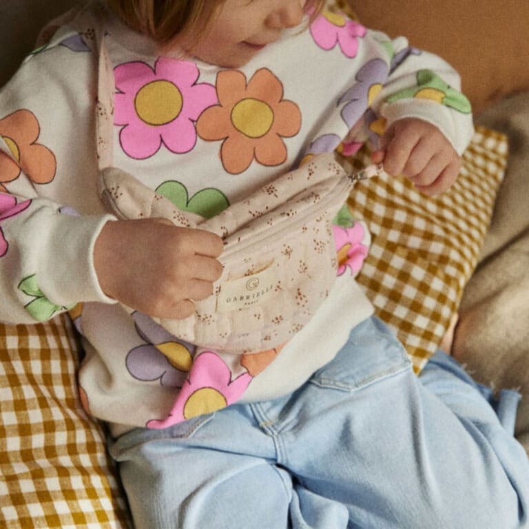 Un sac banane enfant au motif étincelle rose poudré, porté