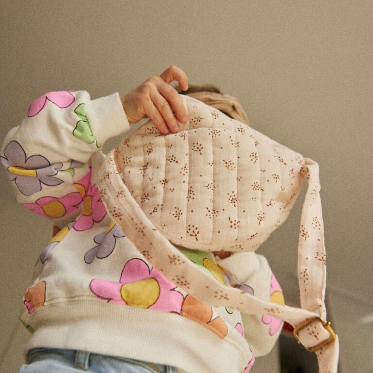 Un sac banane enfant au motif étincelle rose poudré, porté