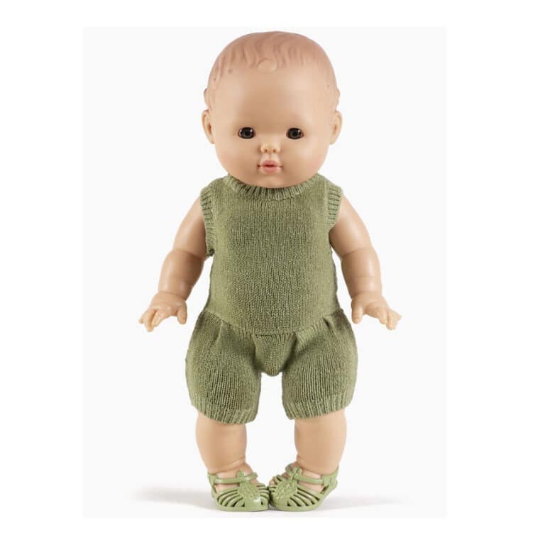une barboteuse en tricot vert sauge, vue de face sur fond blanc avec poupée
