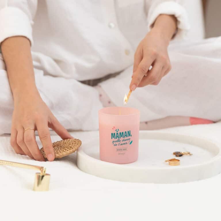 une bougie parfumée avec une inscription "Maman, quelle chance de t'avoir", vue de face et utilisée