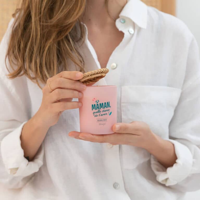 une bougie parfumée avec une inscription "Maman, quelle chance de t'avoir", vue de face et utilisée
