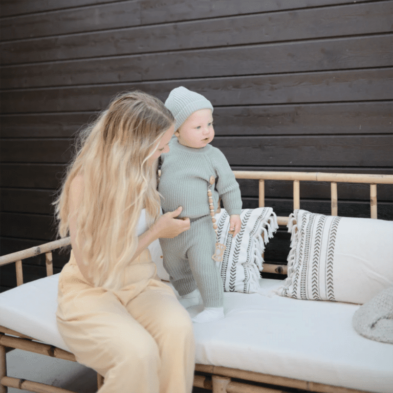 attache tétine "luna" couleur bois mushie photo maman et bébé sur un banc