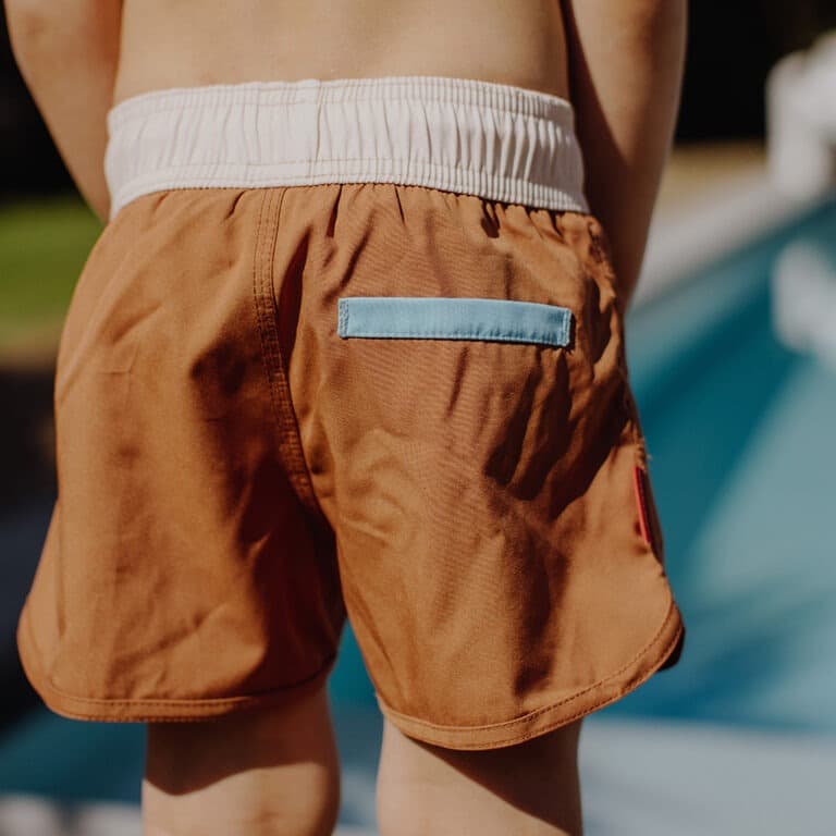 Avec ce joli short de bain "iced coffee" de la marque Hello Hossy, votre enfant pourra s'amuser à la piscine et à la plage tout en ayant du style !