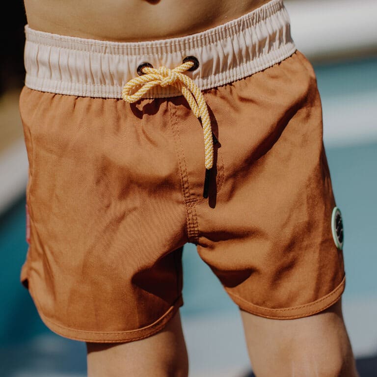 Avec ce joli short de bain "iced coffee" de la marque Hello Hossy, votre enfant pourra s'amuser à la piscine et à la plage tout en ayant du style !