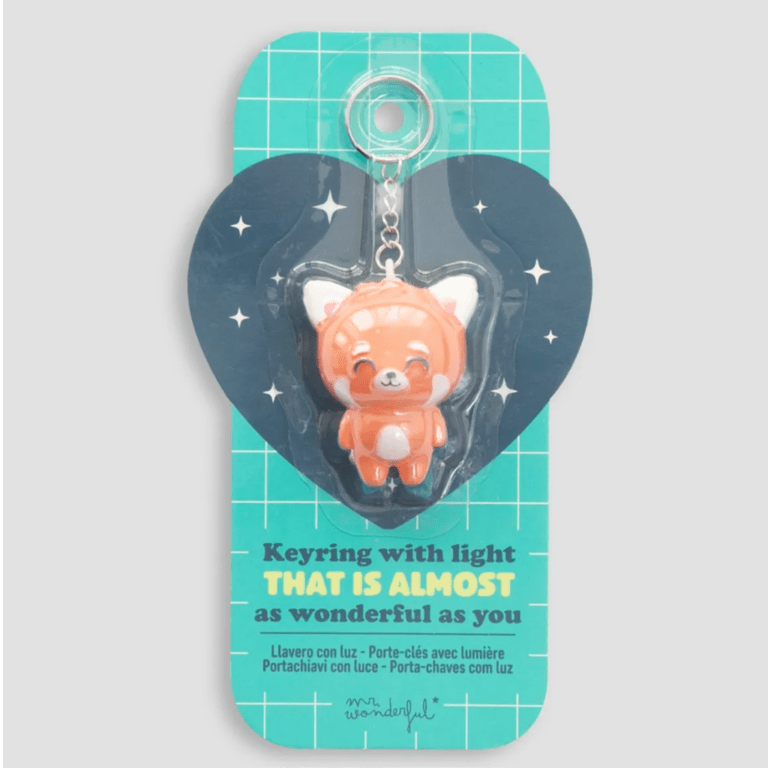 un porte clé en forme de panda roux lumineux, vue de face avec son emballage sur fond blanc