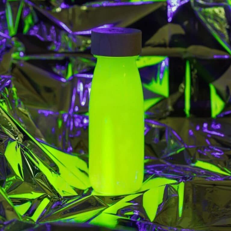 une bouteille sensorielle jaune fluo, vue dans le noir