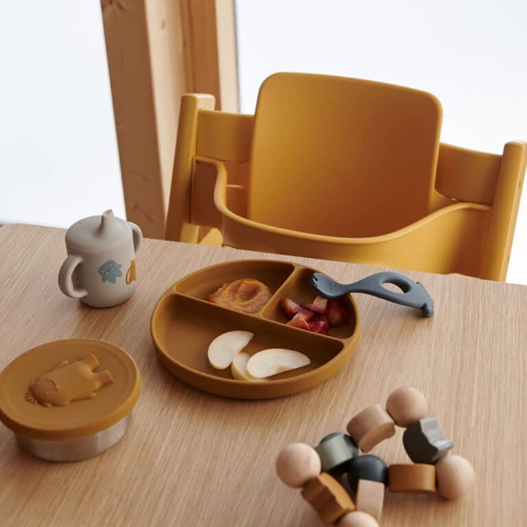 boîte à gouter raymon en silicone liewood monstre moutarde posé sur table