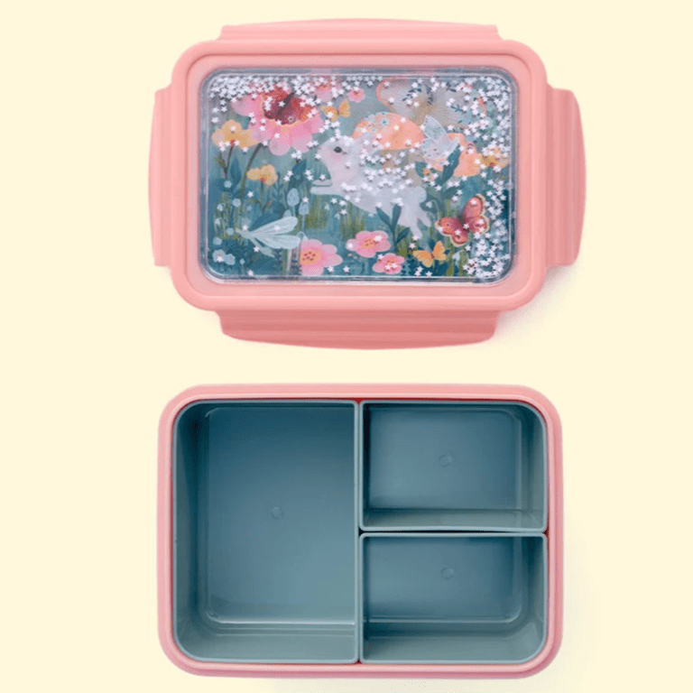 une boîte à repas lapin avec un couvercle à paillettes. Il y a trois compartiments amovibles. Vue de face ouvert sur fond beige