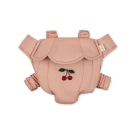 un porte poupée rose avec une petite cerise Konges Slojd, vue de face sur fond blanc