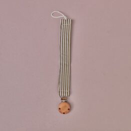 attache tétine à rayures kaki gabrielle paris sur fond rose