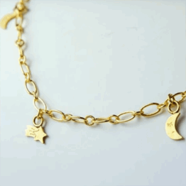 un bracelet charms lune et étoiles filantes Adorabili, vue de face sur fond gris