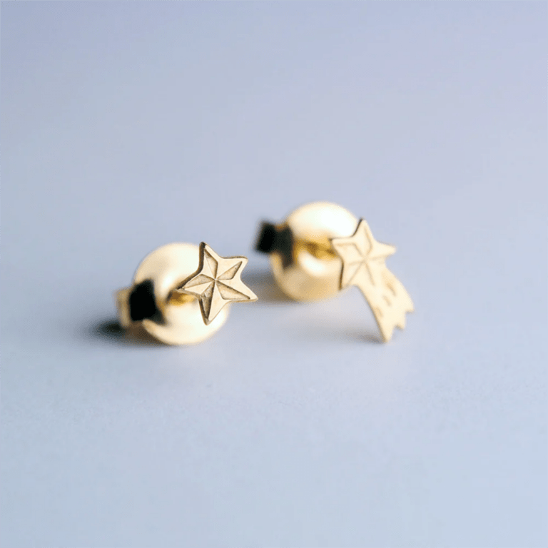 des boucles d'oreilles asymétrique étoile filante et étoile Adorabili, vue de face sur fond gris