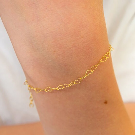 un bracelet avec une chaîne en forme de cœurs Adorabili, porté