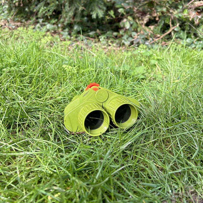 jumelles vertes bass&bass posée dans l'herbe