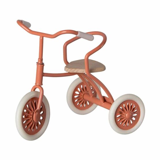 un tricycle corail Maileg, vue de face sur fond blanc