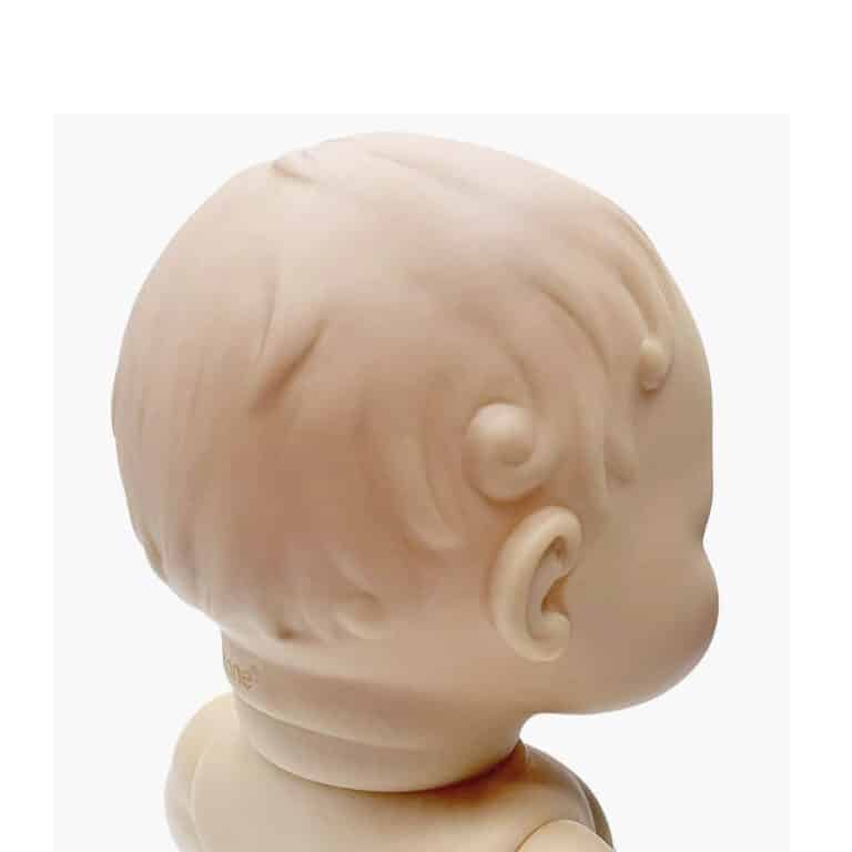 une poupée Louis "vintage" Minikane, vue de derrière sur fond blanc