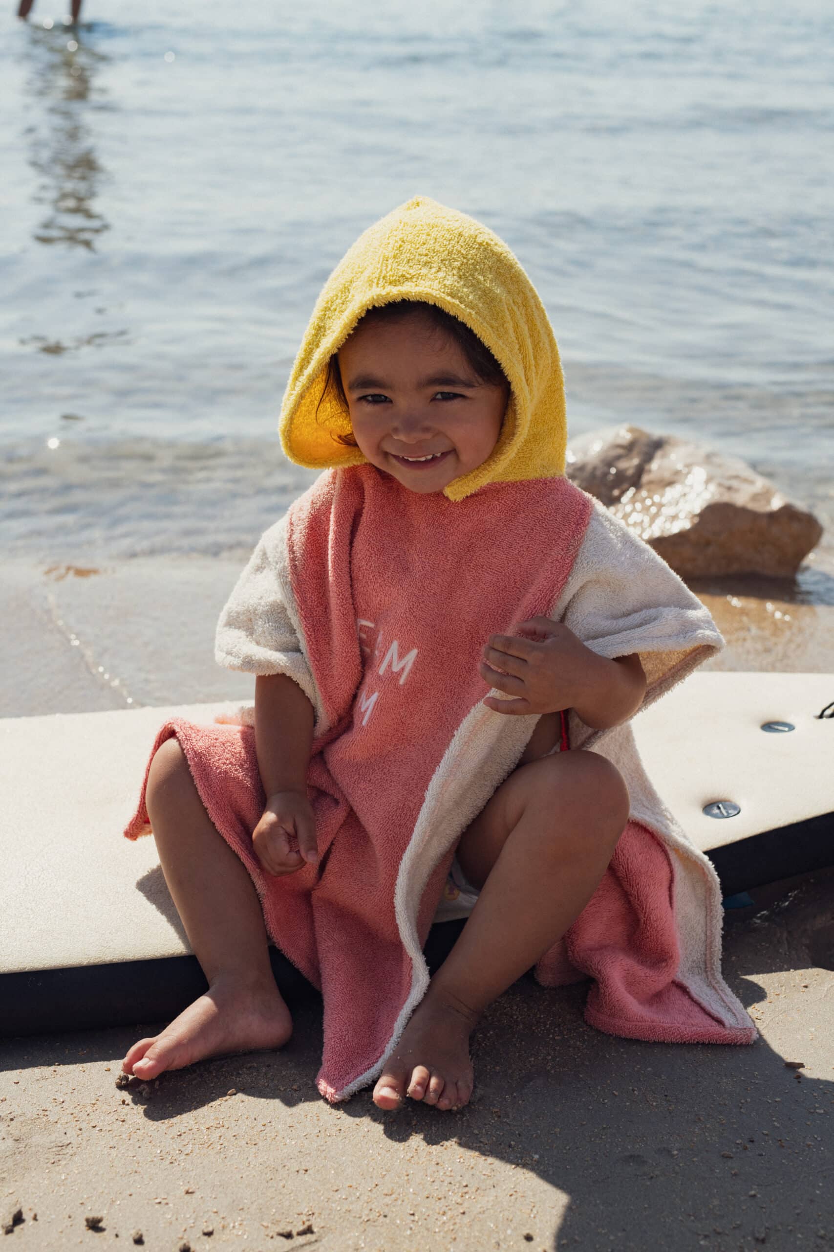 Poncho éponge rose et jaune "dream team" - Chamaye, vue de face porté par un enfant
