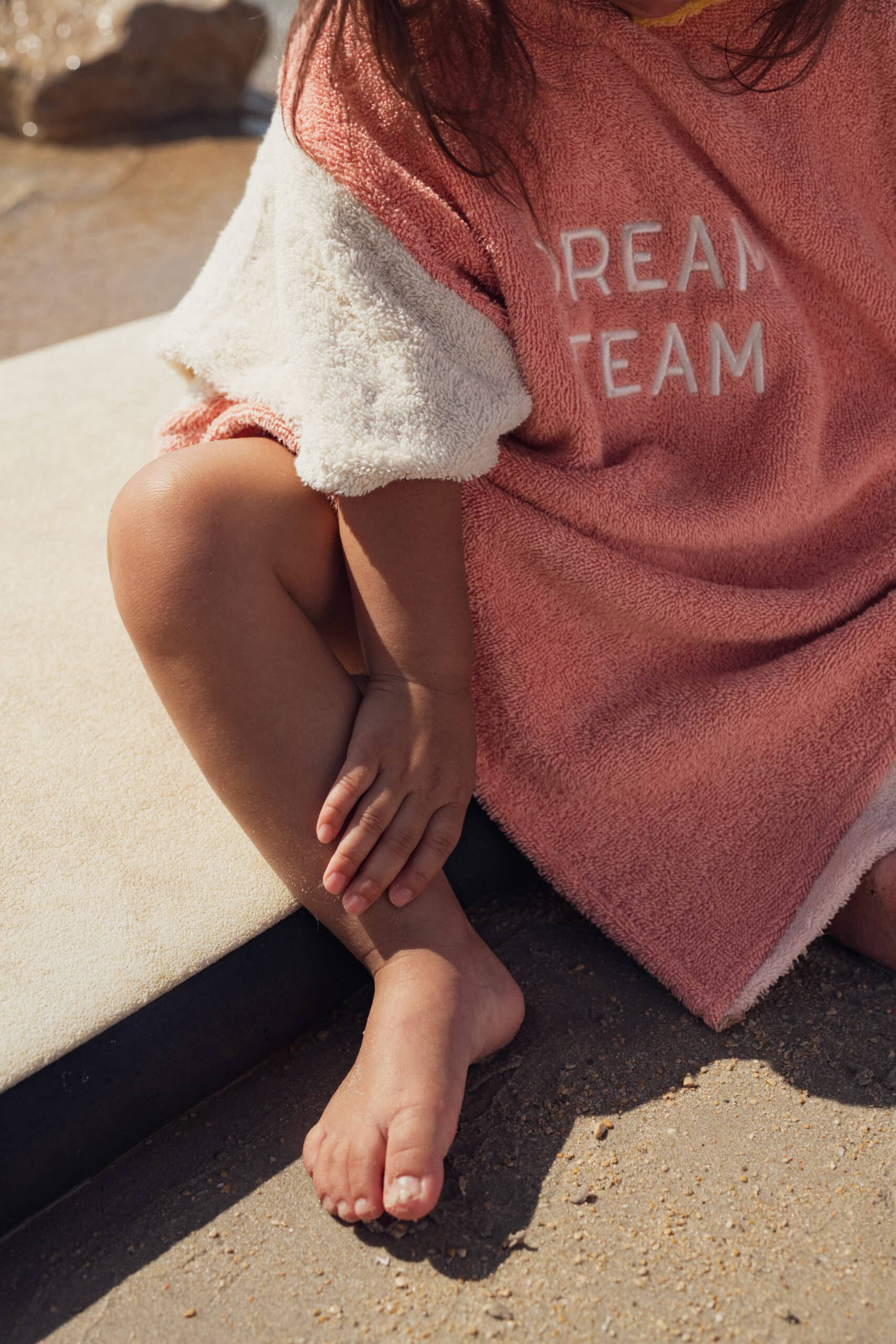 Poncho éponge rose et jaune "dream team" - Chamaye, vue avec zoom de face porté par un enfant