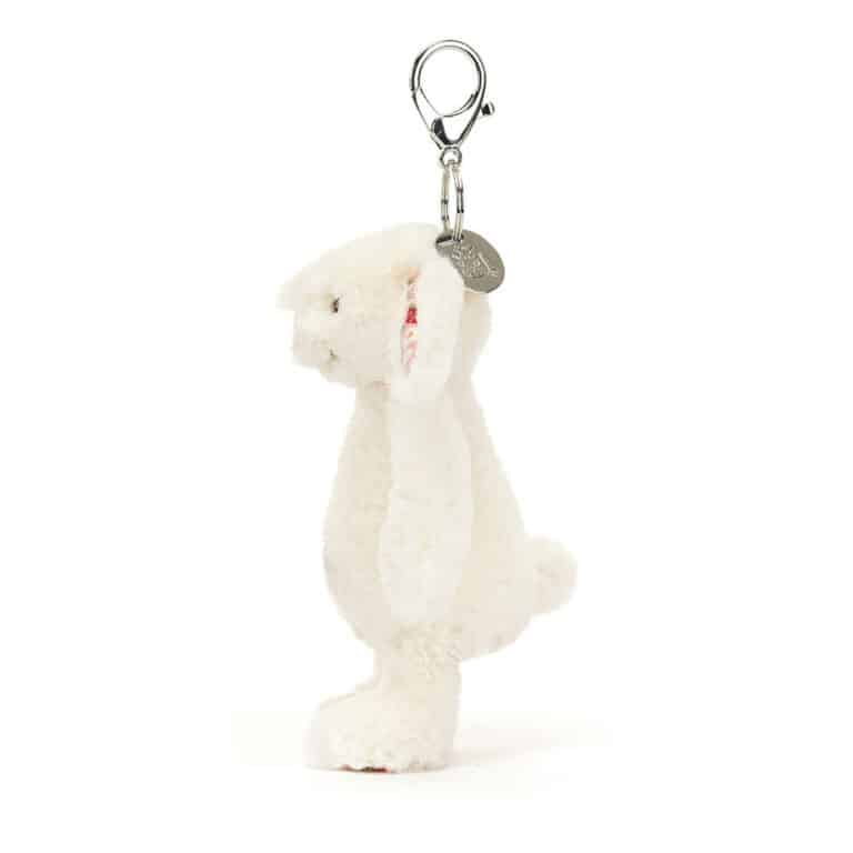 Porte-clé lapin crème aux oreilles petites fraises  –  Jellycat - Vu de côté sur fond blanc
