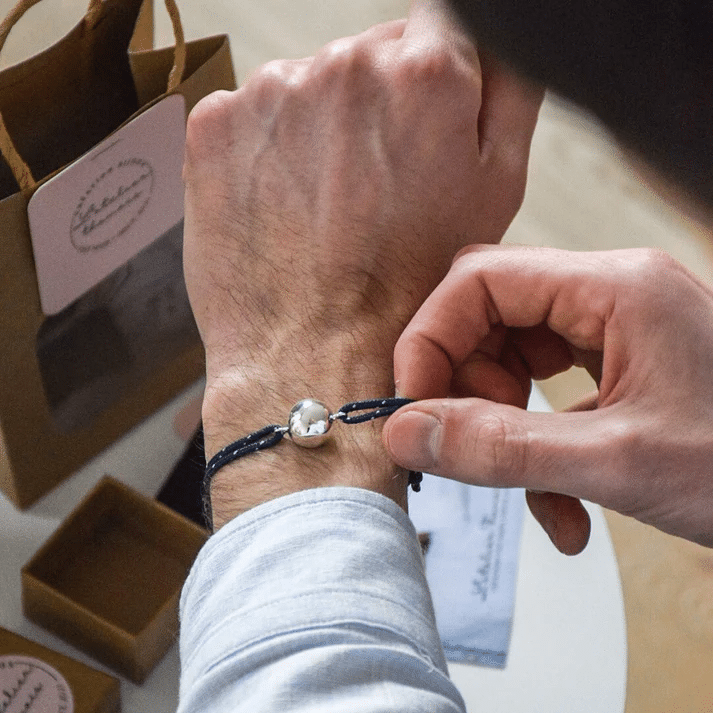 Bracelet bola papa - Marine - Atelier Thamaïs, vue de face porté sur un fond d'ambiance