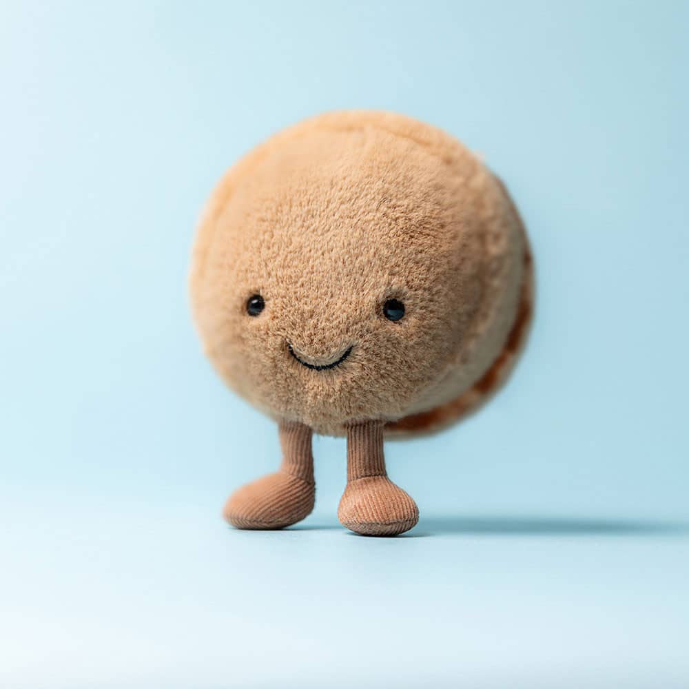 Doudou Macaron Chocolat Mona Amuseables – Jellycat - Vu de face sur fond bleu