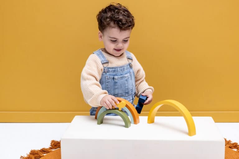 Arc-en-ciel à empiler en bois - Mr Lion - Trixie Baby, vue d'ambiance avec un enfant qui joue