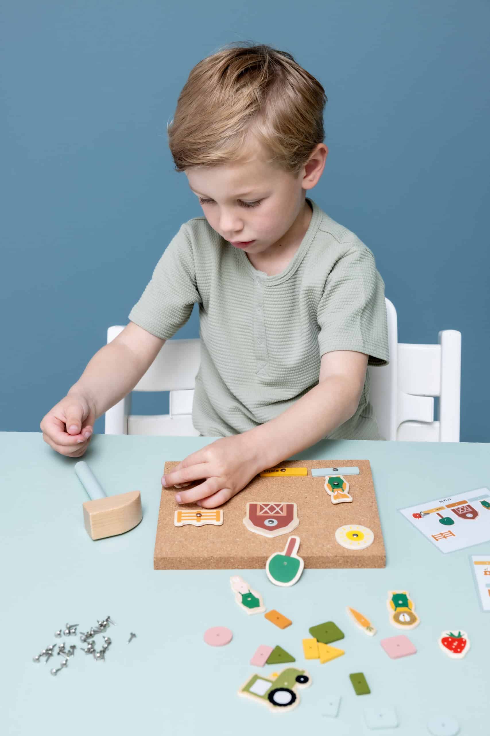 Jeu de clous en bois de la ferme - Trixie Baby - Vue d'ambiance d'un enfant qui joue