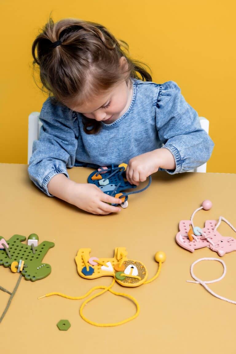 Jeux de laçage animaux en bois - Trixie Baby - Vue d'ambiance d'une enfant qui joue avec Mlle Elephant