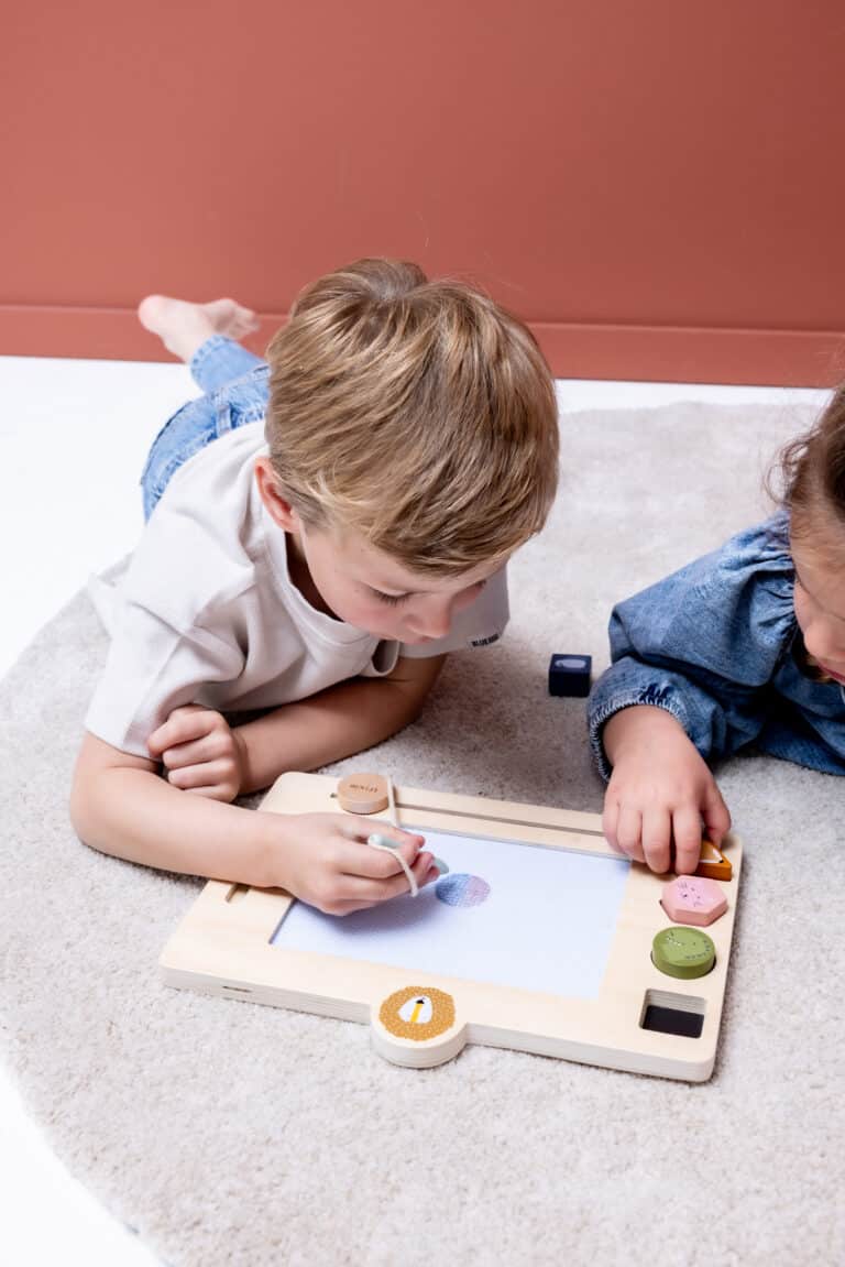 Tableau à dessin en bois Mr.Lion - Trixie Baby - Vue d'ambiance avec deux enfants qui jouent avec le tableau