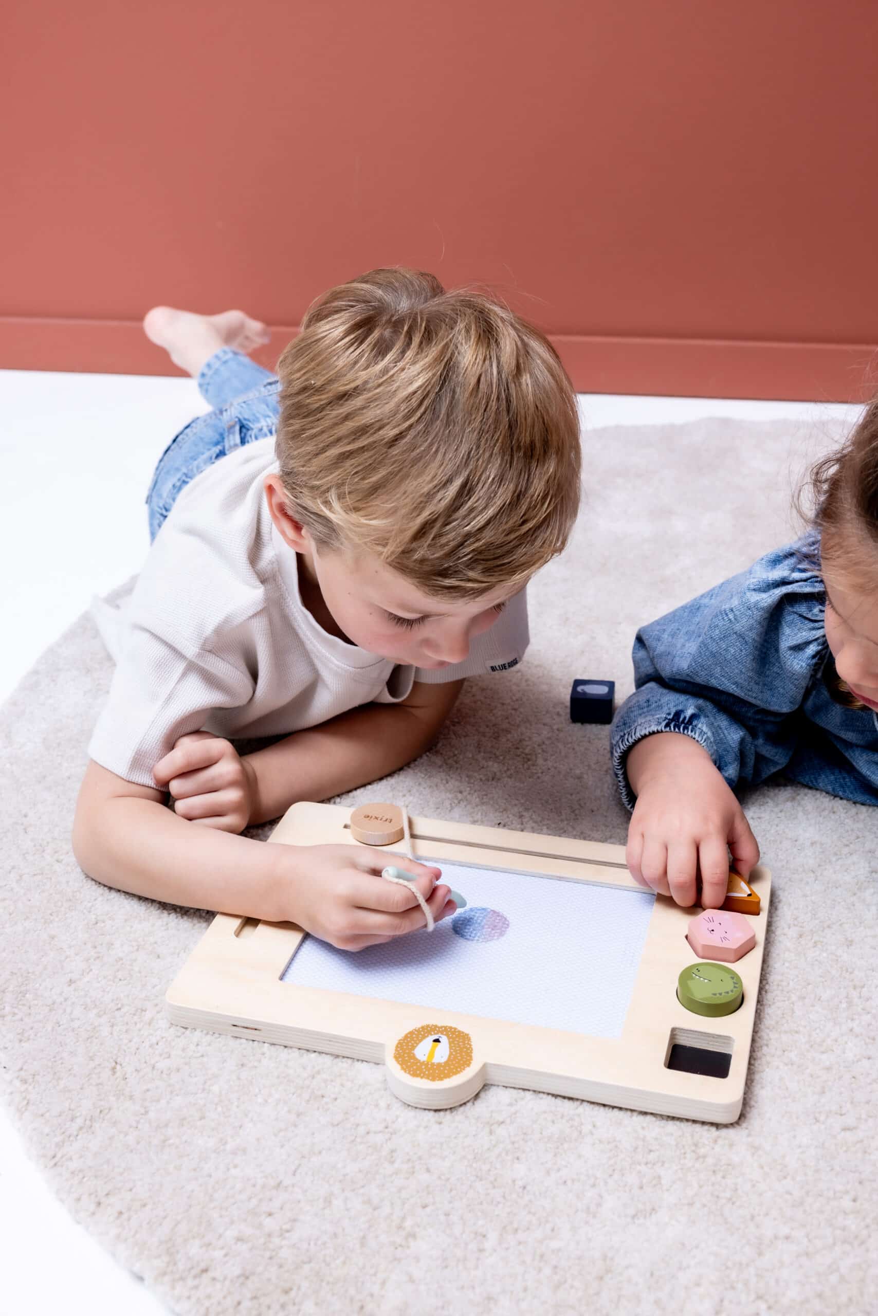 Tableau à dessin en bois Mr.Lion - Trixie Baby - Vue d'ambiance avec deux enfants qui jouent avec le tableau
