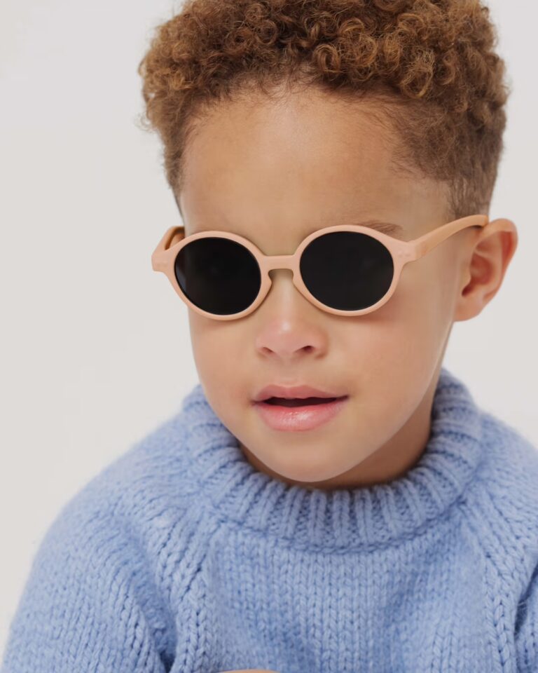 Lunettes de soleil baby #D - Apricot - 0-3 ans - Izipizi, vue de face portée par un enfant