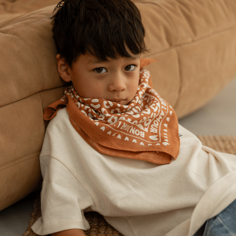 Petit foulard marron avec motif léopard crème - Atelier Wagram, vue de face porté par un enfant