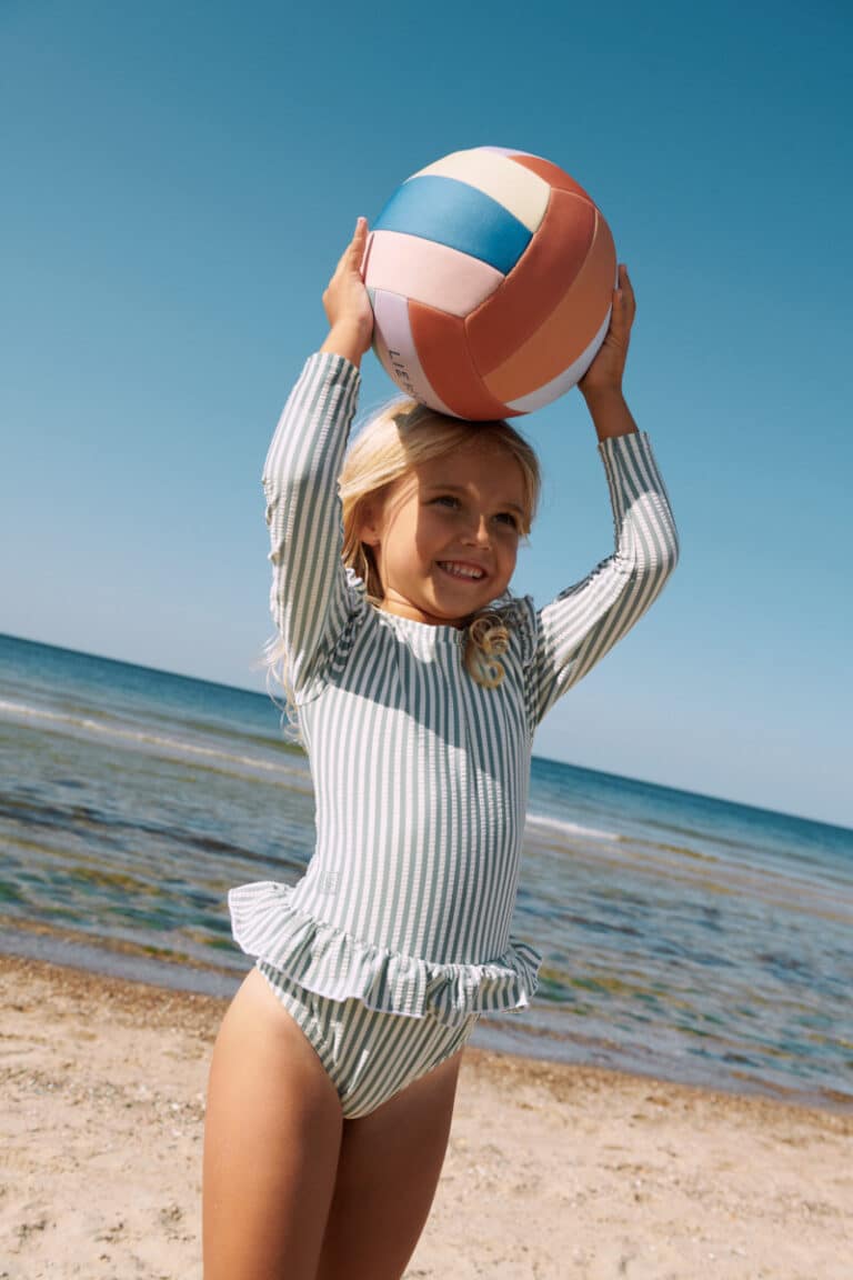 Ballon de volley Villa Crispy Corn Multi Mix - Liewood, vue d'ambiance avec une petite fille sur la plage
