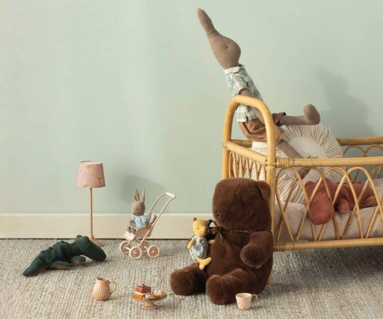 Doudou ours avec son noeud - Marron chocolat -Maileg, vue de profil sur fond d'ambiance