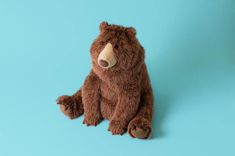 Bizzlestomp Bear -Jellycat, vue de biais sur fond coloré